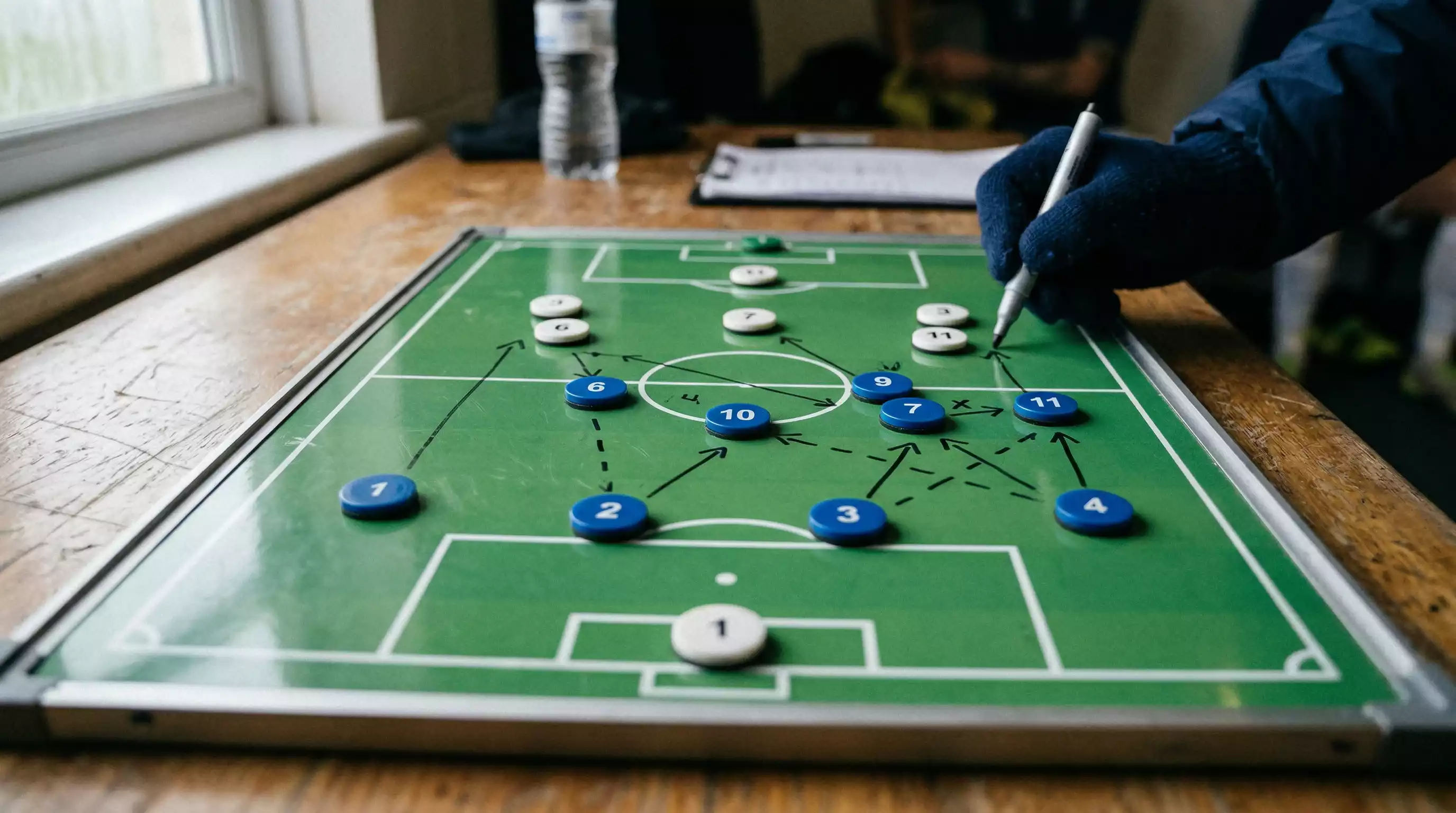 Taktiktavle med fodboldopstilling og linjer der viser spillermønstre