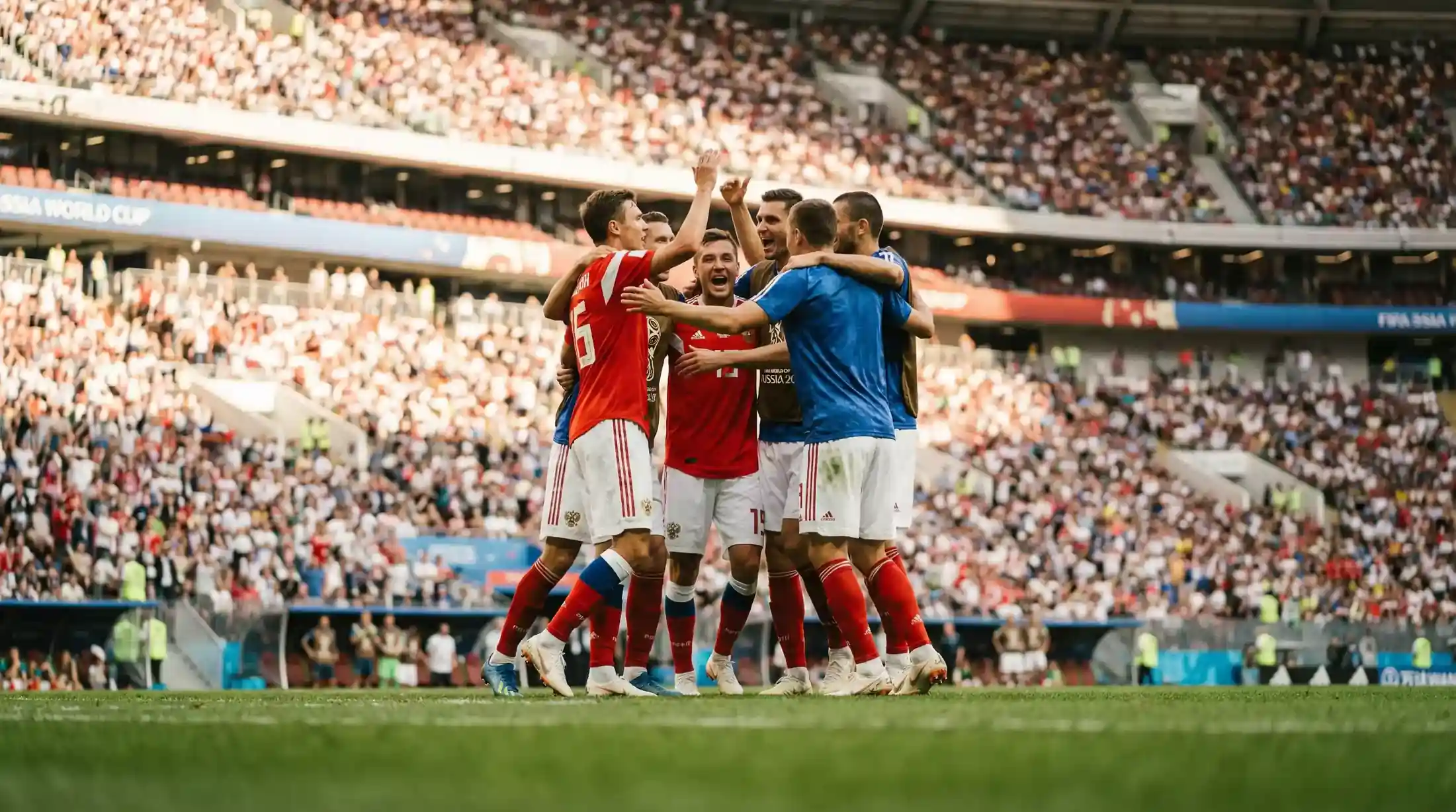 Fodboldspillere i landsholdstrøjer jubler efter scoring på et stort VM-stadion