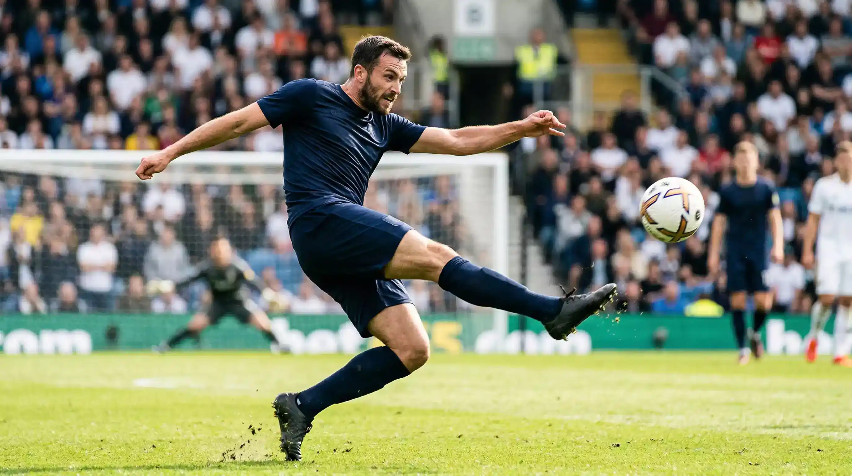 Spiller sparker en kraftfuld skud mod målet på stadionbanen