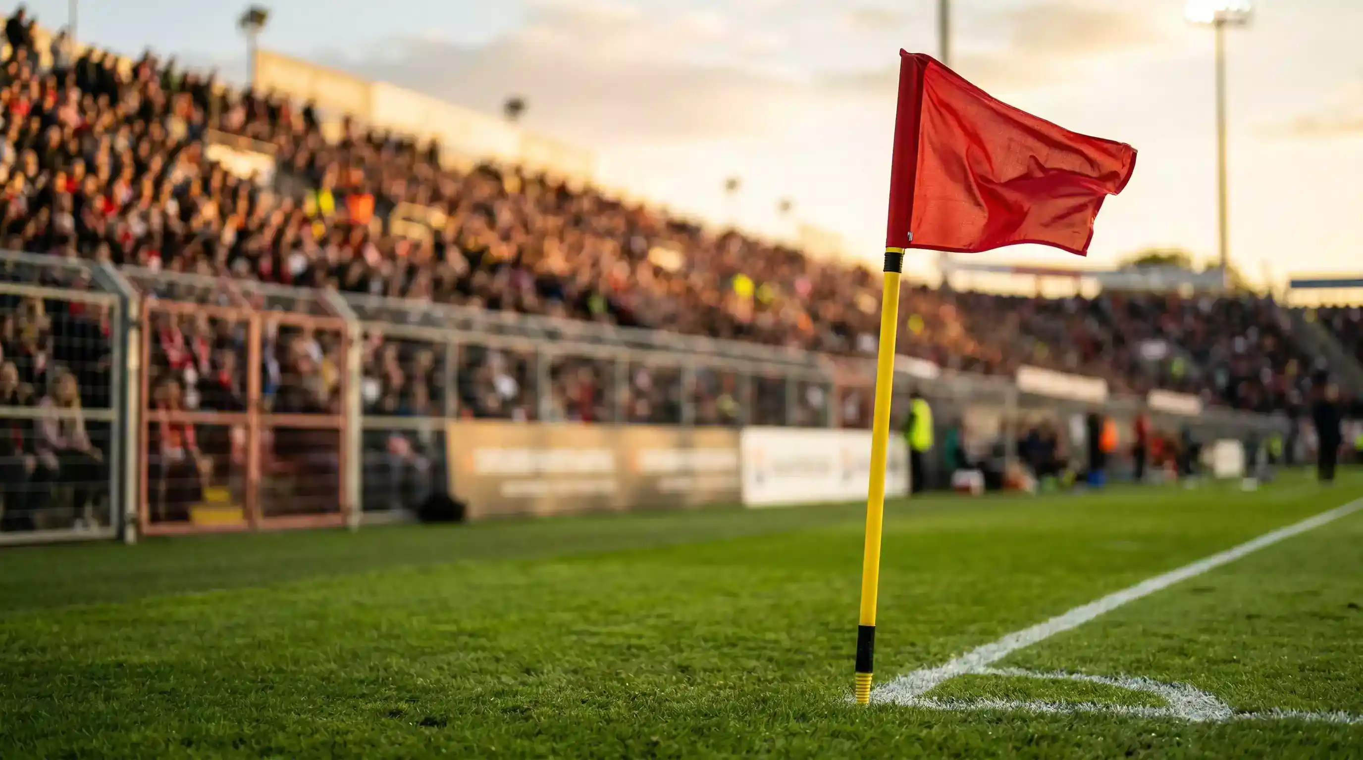 Hjørneflag vajer på en fodboldbane med tilskuertribuner i baggrunden